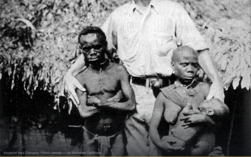 African pygmies and a European explorer — related to Scramble for Africa — Colonial History Whitewashed