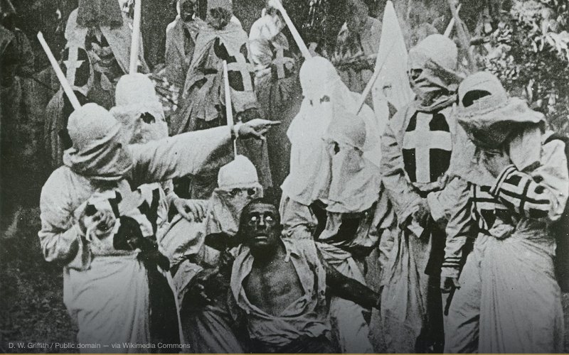 Group of Klansmen surround freedman Gus (played by white actor Walter Long in blackface) in a scene from director D. W. Griffith's 1915 motion picture The Birth of a Nation. — related to Lost Cause of the Confederacy